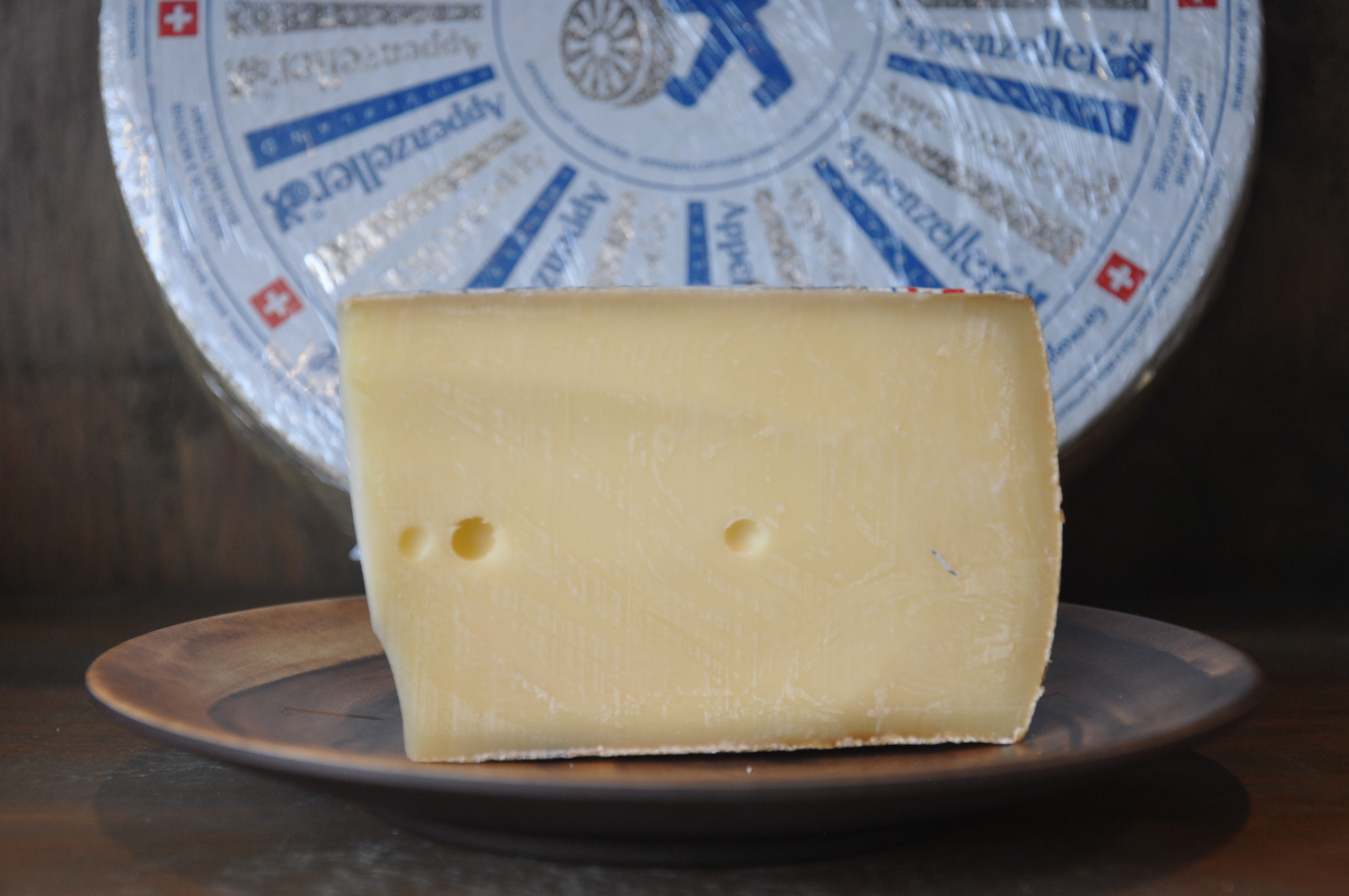 Wheel of Appenzeller White cheese on a rustic wooden board